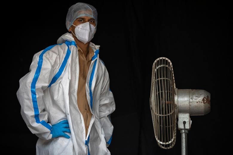 A health worker takes a break while waiting for people to collect samples to test for the coronavirus in New Delhi, India. REUTERS/Danish Siddiqui    